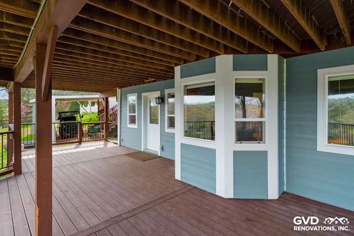 Newly installed James Hardie siding in blue on a home's exterior, featuring a cozy porch and modern design
