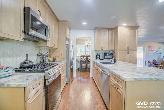 Modern kitchen remodel featuring light wood cabinets, gray quartz countertops, and a stylish backsplash in Sacramento home