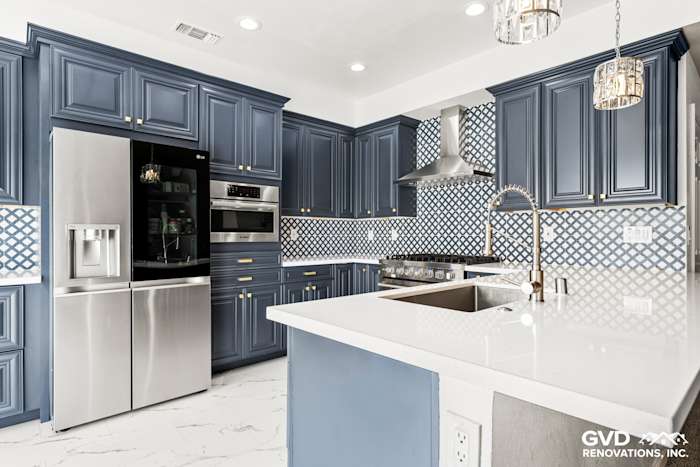 Modern kitchen remodel with navy blue cabinets, quartz countertops, stainless steel appliances, and patterned backsplash