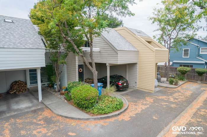 Updated quadplex exterior featuring James Hardie siding in beige, surrounded by greenery and parking space in Santa Rosa