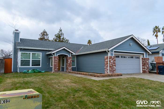 Home exterior featuring James Hardie siding in Boothbay Blue, Arctic White trim, and brick accents in Sacramento