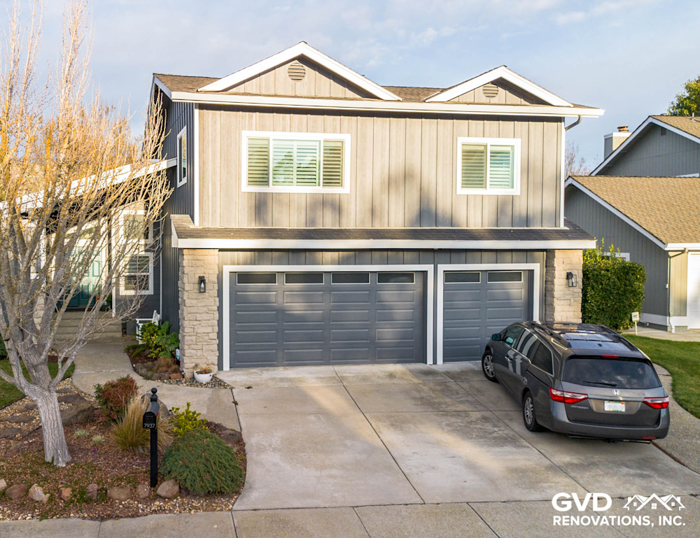 Modern gray siding with sleek dark garage doors and coordinated trim