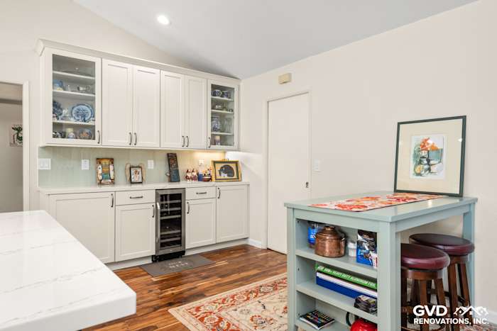 Custom kitchen cabinets with a wine cooler, wooden flooring, and decorative countertop in Carmichael remodel