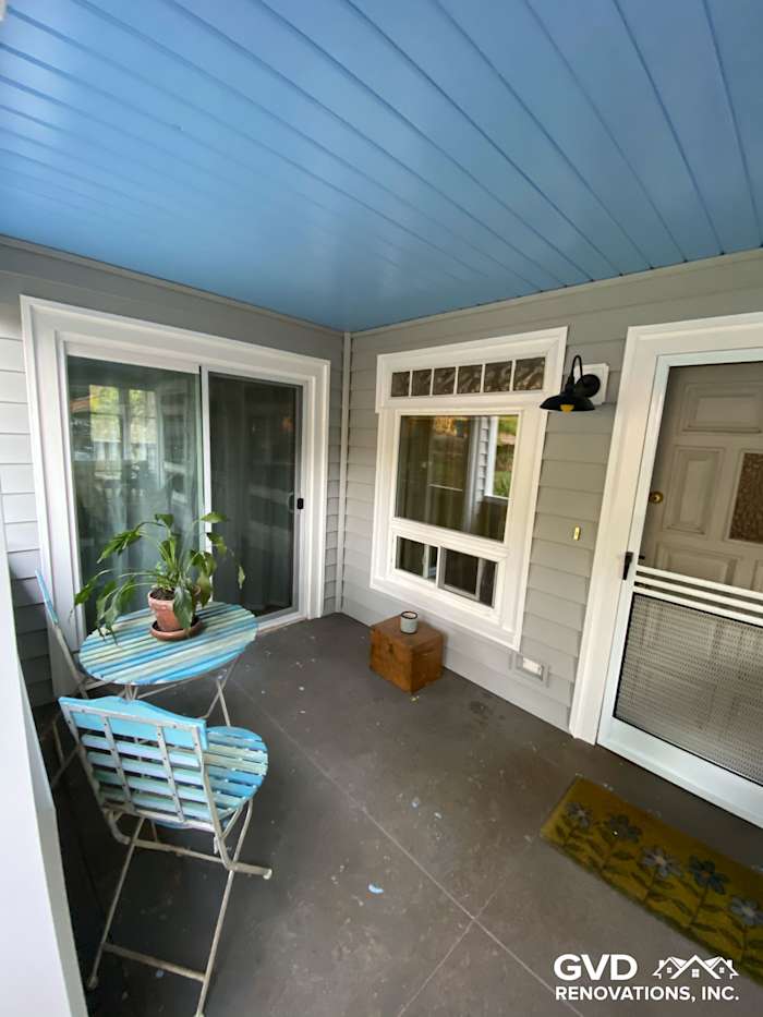Brightly painted porch with Prodigy vinyl siding, blue ceiling, and small dining set