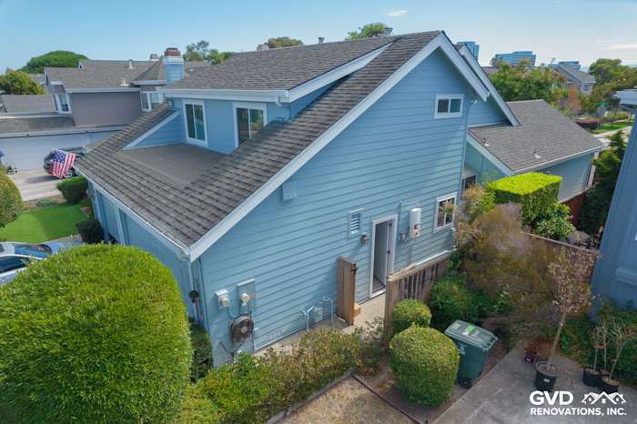 Transformed home exterior featuring James Hardie siding, new Alside windows, and landscaped yard in Foster City