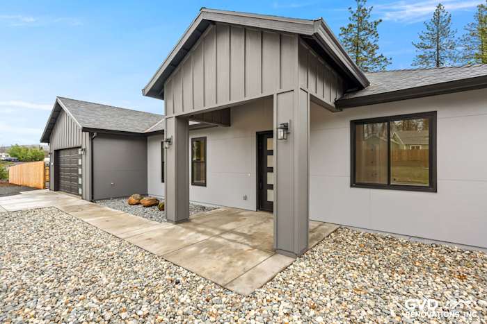 Modern home exterior featuring James Hardie Architectural Panels in Sea Grass, Milgard black windows, and stone landscaping