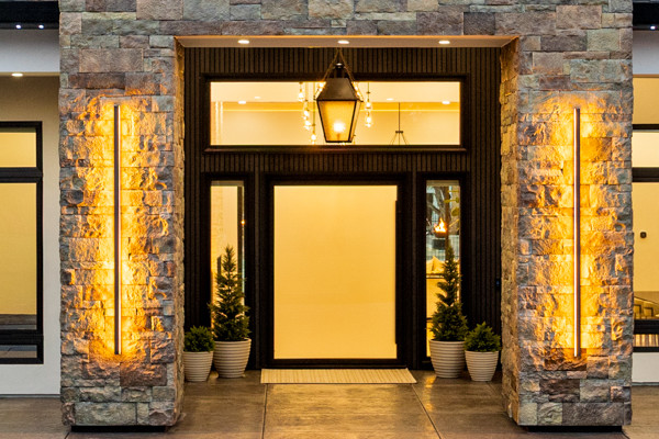 Modern prairie home exterior in Penryn with stone columns, integrated LED uplighting, and landscaped front yard
