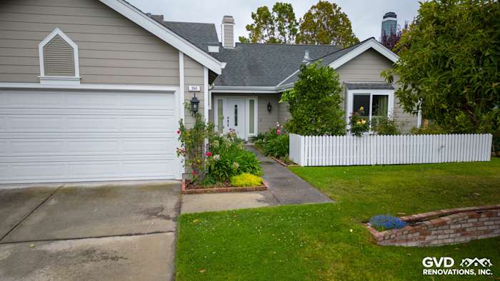 Home exterior featuring James Hardie siding in Monterey Taupe and Milgard windows, with white picket fence