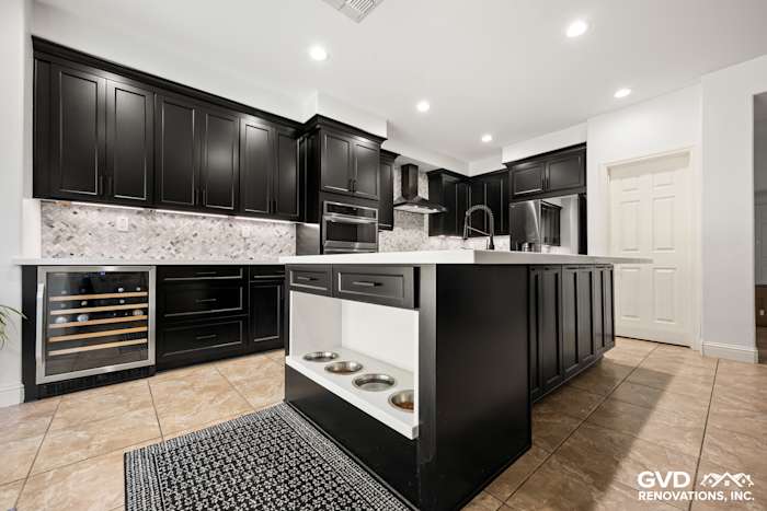 Modern kitchen in Roseville with black Waypoint cabinets, MSI mitered-edge countertop, and built-in pet feeding station