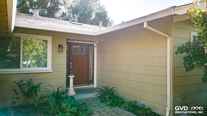 Carmichael home featuring James Hardie siding and a stylish front entryway with wooden door