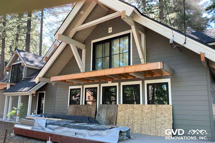 Modern home exterior featuring James Hardie siding in muted gray with large black-framed windows, Tahoe City
