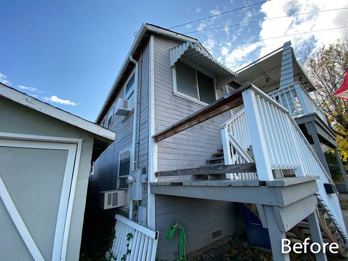 Old home exterior showcasing outdated gray wood siding, steps, and a partly enclosed porch in Rio Vista, CA
