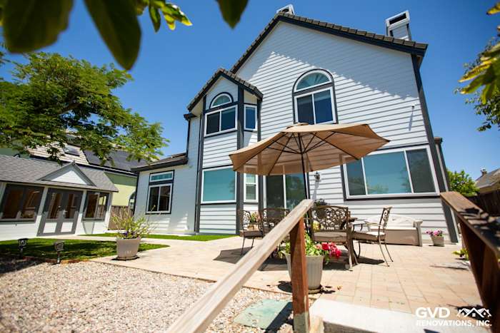 Arctic White James Hardie lap siding with Iron Gray trim on a remodeled home in Hayward, featuring a patio area