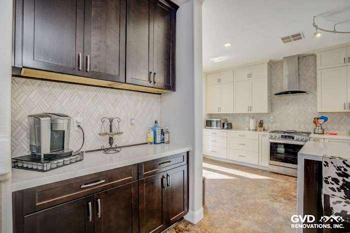 Modern kitchen remodel featuring herringbone backsplash, dark wood cabinets, and stainless steel appliances in Roseville