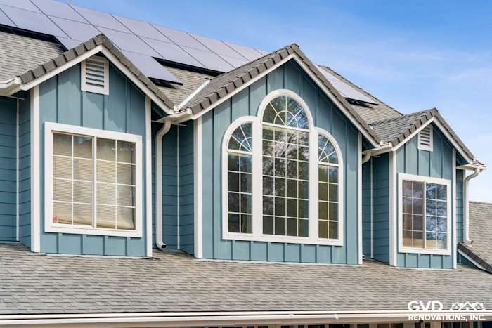 New James Hardie siding in blue on home exterior with large arched window and solar panels, Shingle Springs remodel