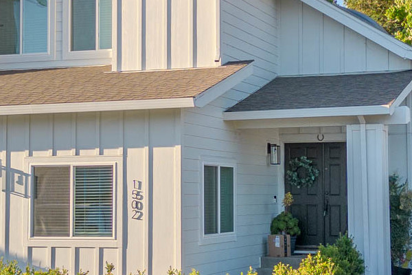 Two-story Petaluma home featuring James Hardie siding in Arctic White and Anlin windows, surrounded by landscaping