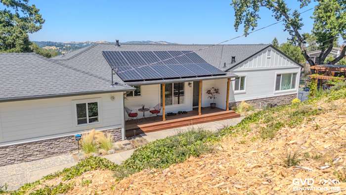 Home exterior featuring James Hardie Artisan and Board and Batten Siding with a rock apron and solar panels