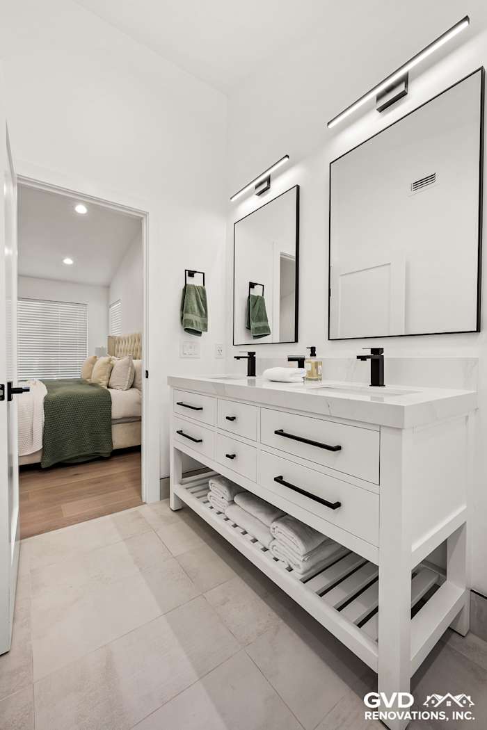 Bright bathroom featuring a modern dual vanity, large mirrors, and neatly arranged towels in Antelope renovation