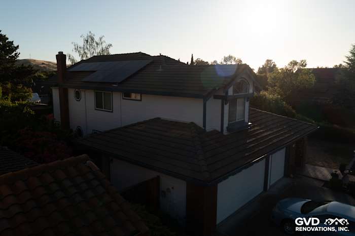 Home exterior featuring Arctic White James Hardie siding and a tiled roof, illuminated by sunset