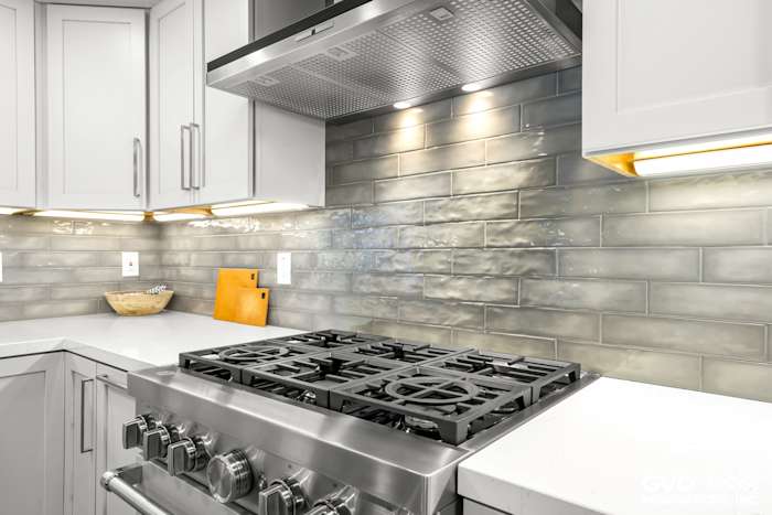 Stainless steel gas range with a sleek backsplash and modern white cabinetry in Rocklin kitchen remodel