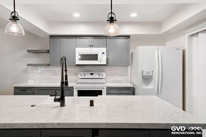 Modern Sacramento kitchen remodel featuring gray cabinets, quartz countertop, stainless steel appliances, and pendant