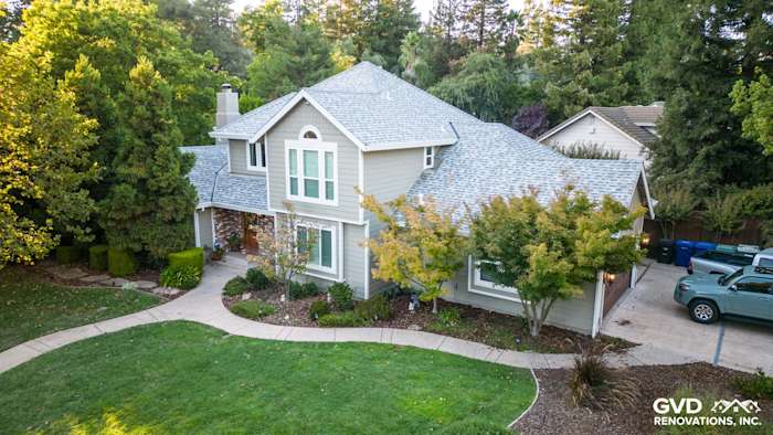 Fair Oaks home featuring James Hardie Monterey Taupe siding and Arctic White trim, surrounded by lush greenery