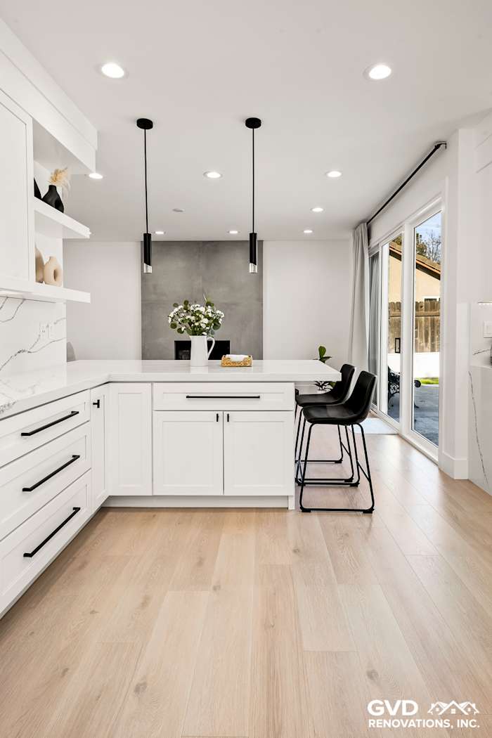 Modern kitchen featuring white custom cabinets, quartz countertops, and pendant lighting in Antelope, CA