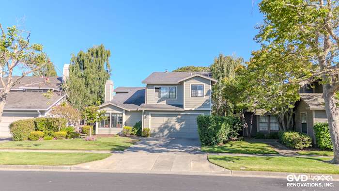 Home exterior in Alameda featuring James Hardie Lap Siding in Monterey Taupe and Andersen A100 Windows. Lush landscaping