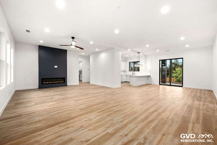Spacious open-concept living area with high ceilings, modern kitchen, and large windows in Paradise home