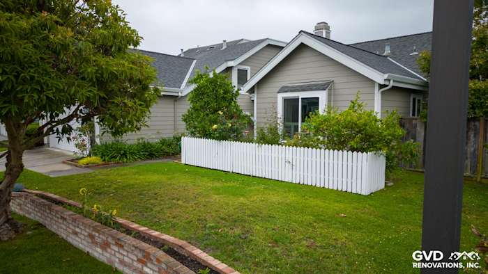 Foster City home exterior featuring James Hardie Monterey Taupe siding, Milgard windows, and white picket fence
