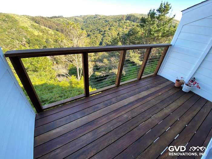 Modern outdoor deck with sleek wood planks and stainless steel railings overlooking a scenic green landscape in Mill Valley