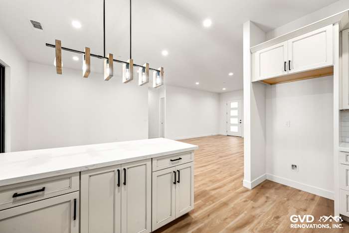 Modern kitchen featuring Waypoint cabinetry, quartz island countertop, and open layout in new construction home