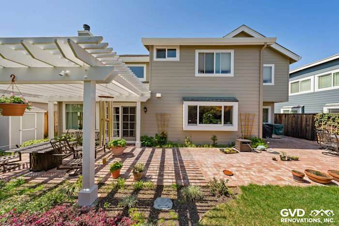 Foster City home exterior with Monterey Taupe James Hardie siding and Arctic White trim, featuring a patio and pergola