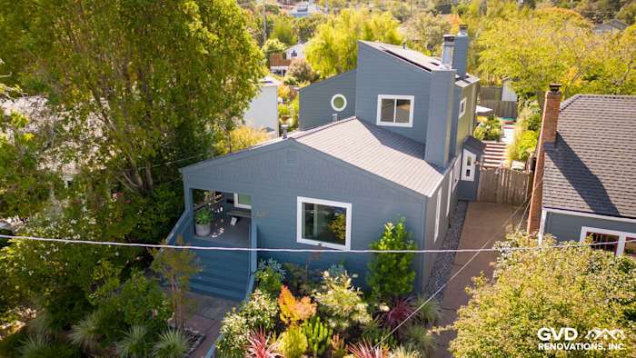 Corte Madera home featuring James Hardie Evening Blue siding and Arctic White trim, surrounded by greenery
