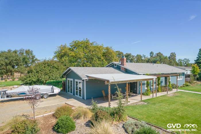 Updated home exterior featuring blue James Hardie siding, a covered porch, and landscaped yard in Wilton, CA