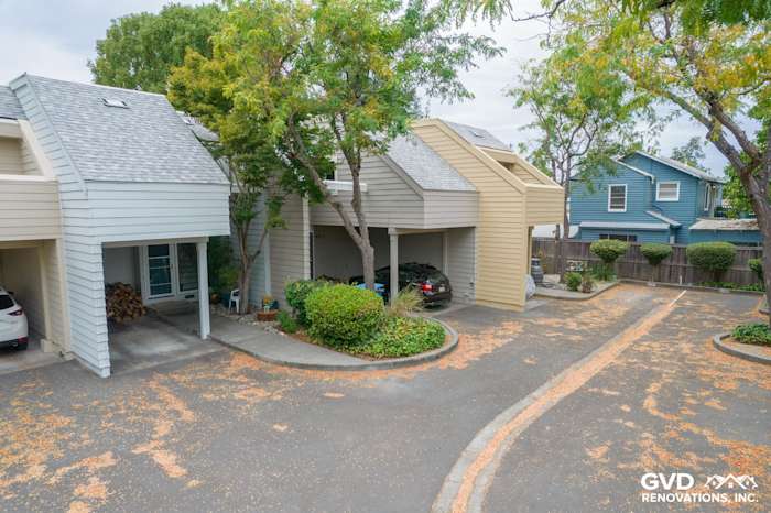 Quadplex exterior featuring newly installed James Hardie siding in soft gray and tan tones, surrounded by landscaped area