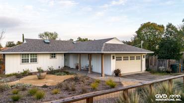 Home exterior featuring James HardiePanel Vertical Siding in Arctic White and landscaped front yard in Pleasant Hill