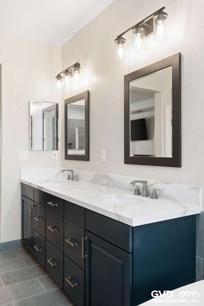 Modern master bathroom with navy cabinets, dual sinks, and stylish lighting in El Dorado Hills