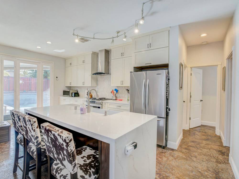 Bright white cabinets, modern countertops, and enhanced open kitchen layout