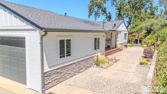 Home exterior in Orinda with James Hardie Artisan siding, rock apron skirting, and custom Anlin Windows