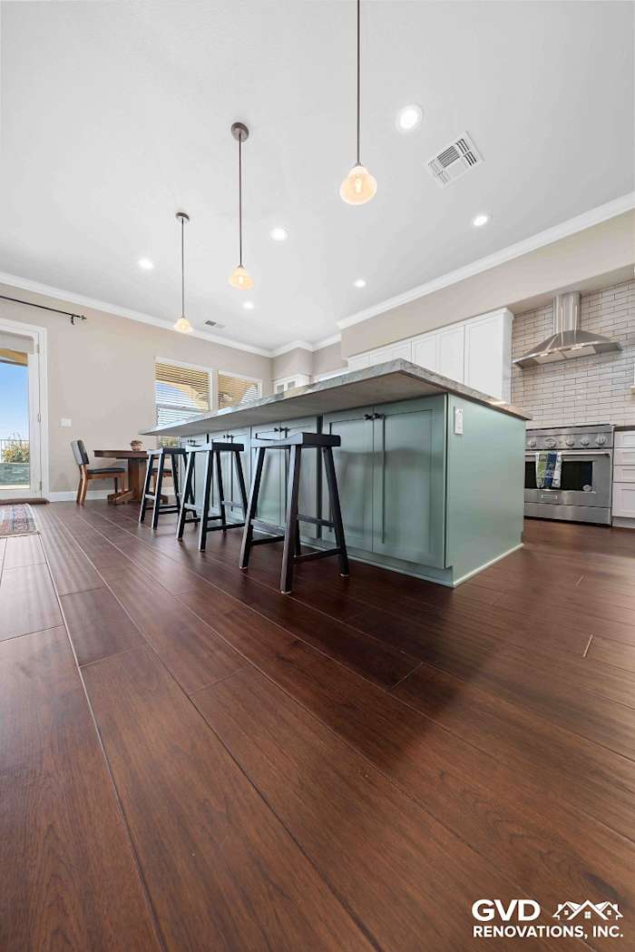 Spacious renovated kitchen in El Dorado Hills with light wood flooring and a large island, featuring pendant lighting