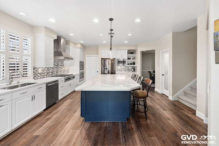 Modern kitchen remodel featuring white cabinetry, navy island, quartz countertops, and wood flooring in El Dorado Hills