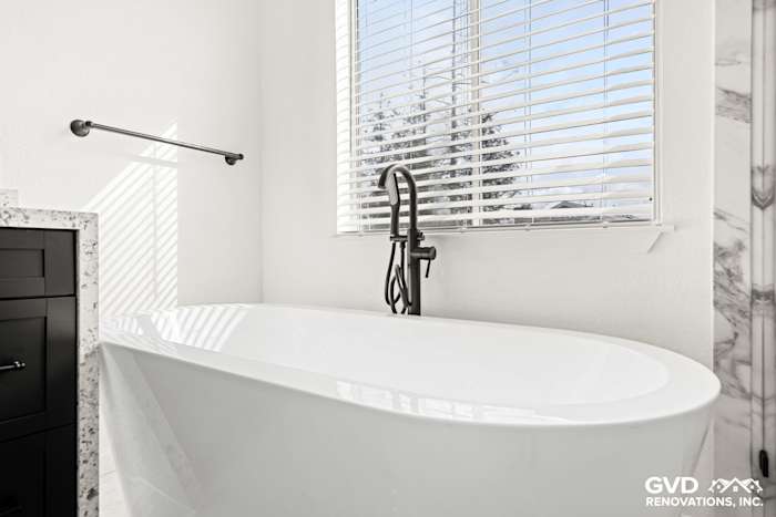 Modern bathroom featuring a freestanding bathtub, double sink vanity, and sleek black faucet in Sacramento remodel