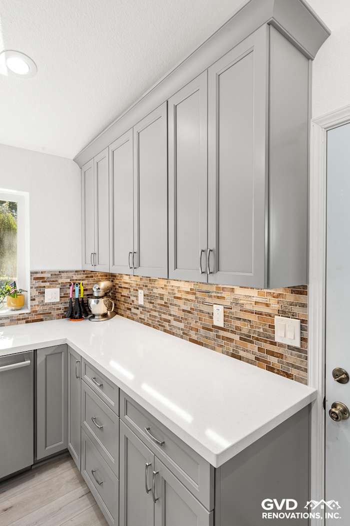Modern kitchen featuring gray cabinetry, quartz countertops, and stylish mosaic backsplash in Greenwood, CA