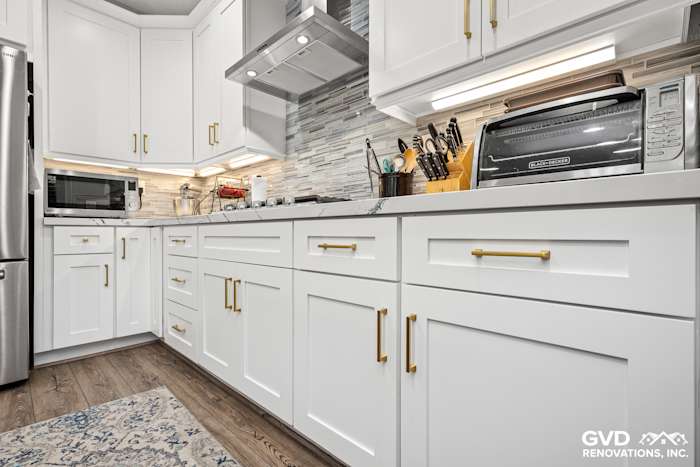 Modern kitchen with white custom cabinets, Cambria countertops, and stainless steel appliances in Roseville, CA