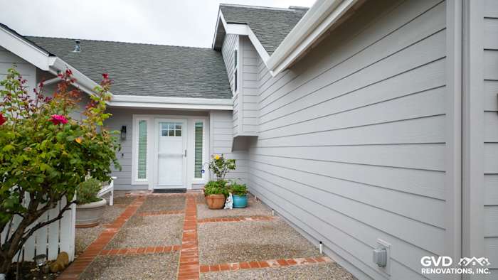 Home exterior with new Pearl Gray James Hardie siding, Milgard windows, and brick walkway in Foster City, CA