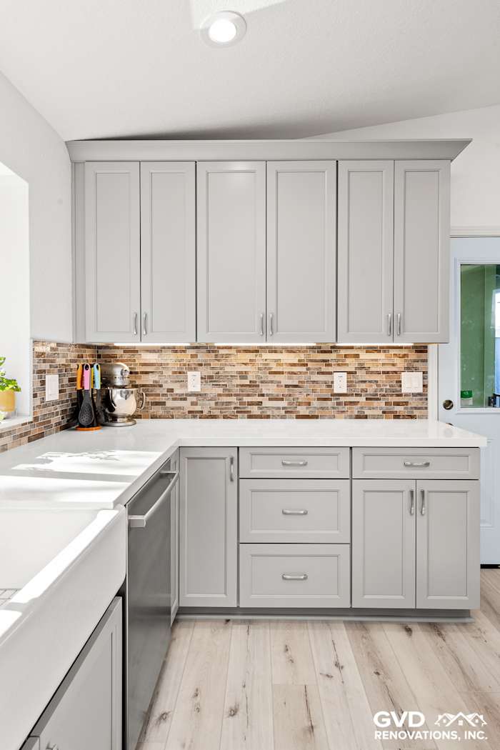 Modern kitchen featuring gray cabinets, quartz countertops, and mosaic tile backsplash in Greenwood, CA remodel