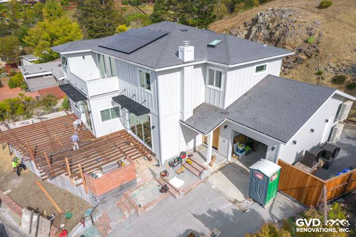 Modern home exterior in Tiburon featuring Artisan Lap Siding, solar panels, and ongoing deck construction