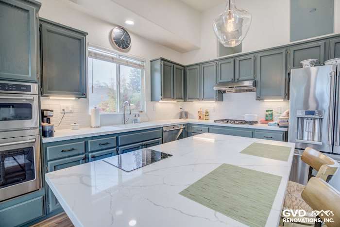 Modern kitchen remodel featuring dark green cabinets, white quartz countertops, and stainless steel appliances in El Dorado
