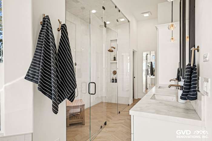 Luxurious master bathroom with glass steam shower, marble countertops, and striped towels in El Dorado Hills